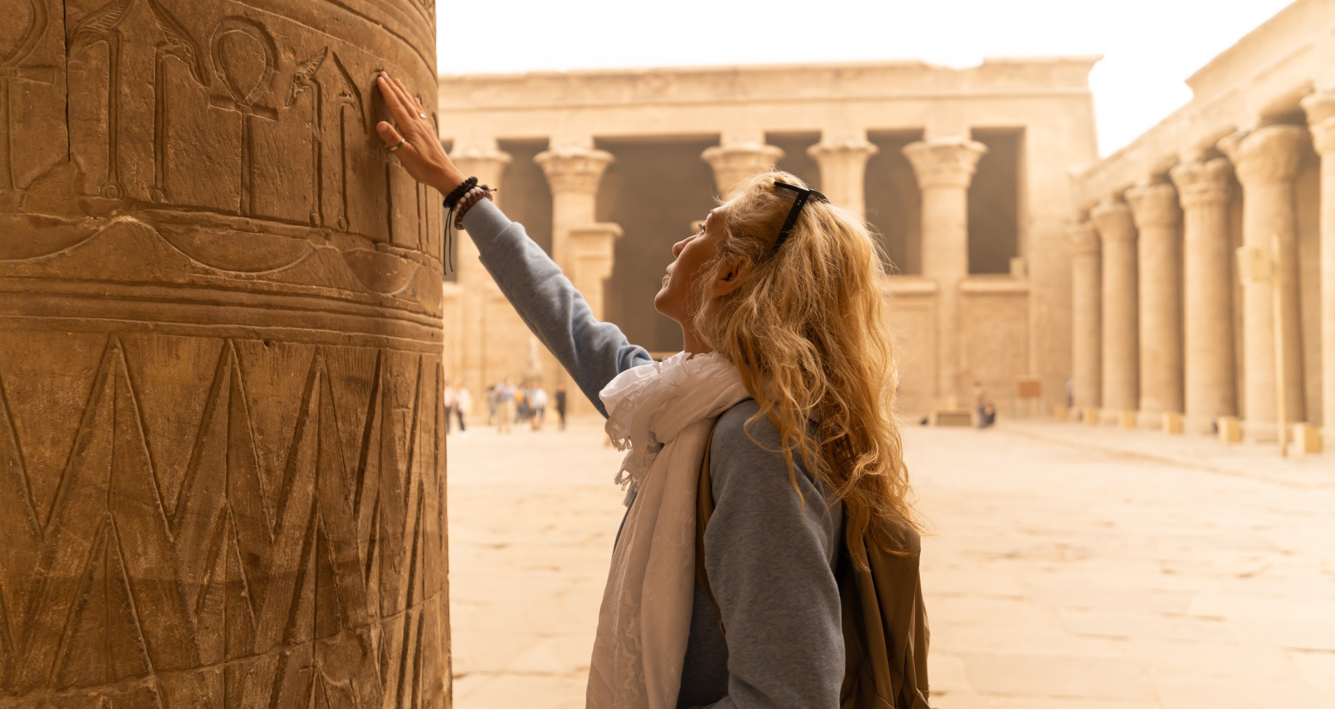 Mujer tocando las columnas del Templo de Edfu