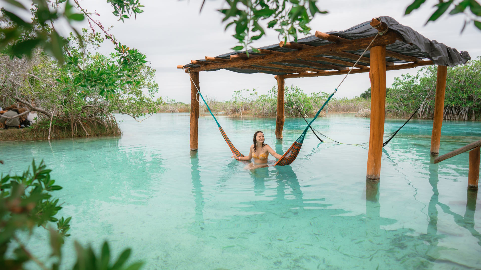 Mujer columpiándose en las aguas de la Laguna de Bacalar en Riviera Maya